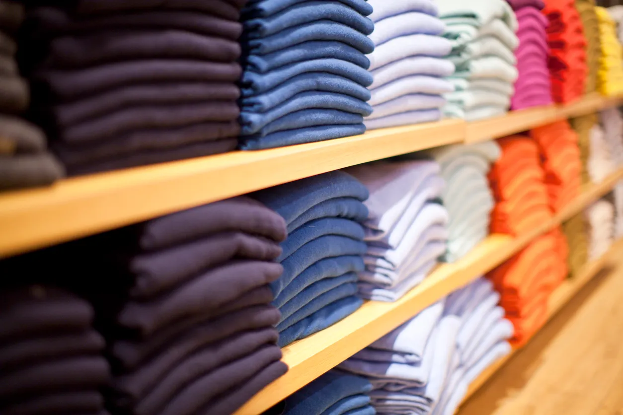 Estante de venta de ropa ordenada por color. La ropa por mayoreo es un negocio muy rentable