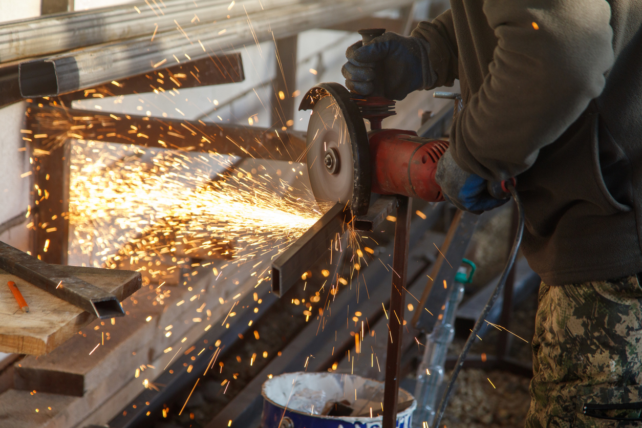 Un hombre está cortando metal con una sierra