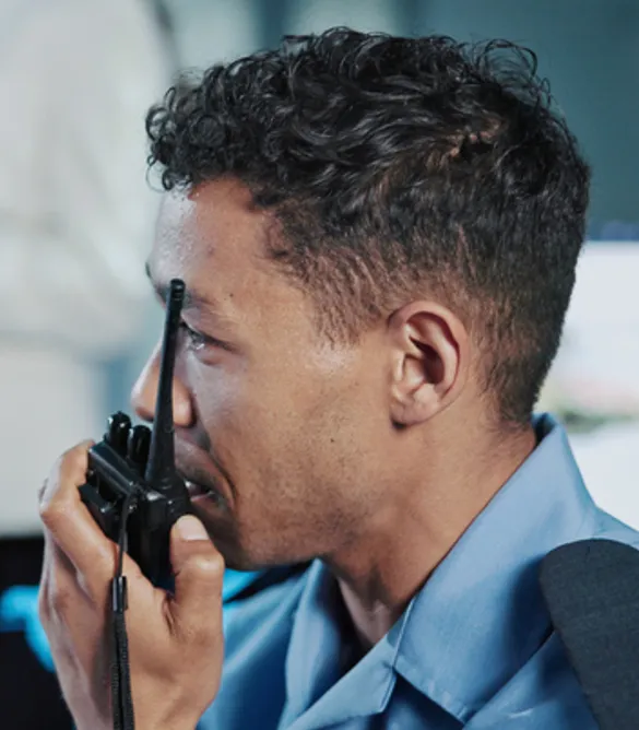 Persona de seguridad hablando por woki toki en una oficina